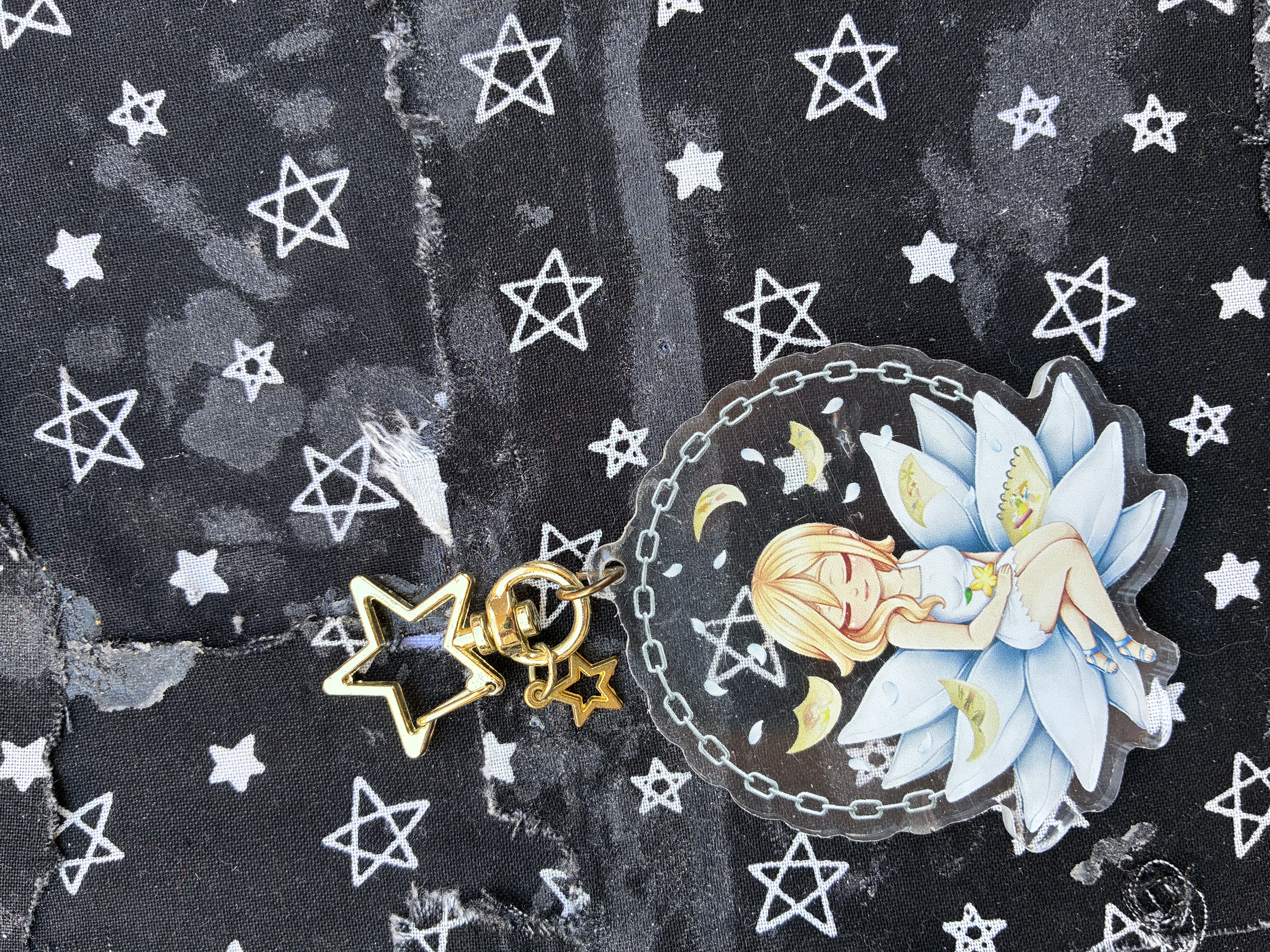 Acrylic charm of Kingdom hearts Namine sitting on a capsule surrounded by her drawings and a chain.